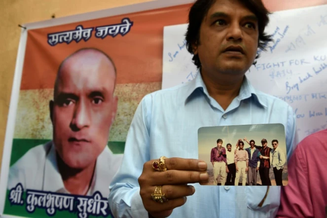Des amis indiens de Kulbhushan Jadhav, condamné à mort au Pakistan, avec une photo où il figure en leur compagnie, à Mumbai le 18 mai 2017