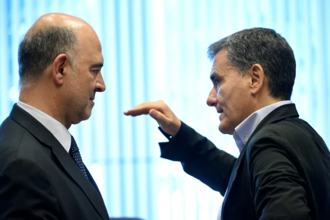 Pierre Moscovici (G) et le ministre grec des Finances Euclid Tsakalotos (D) lors d'une réunion de l'Eurogroupe à Luxembourg, le 21 juin 2018