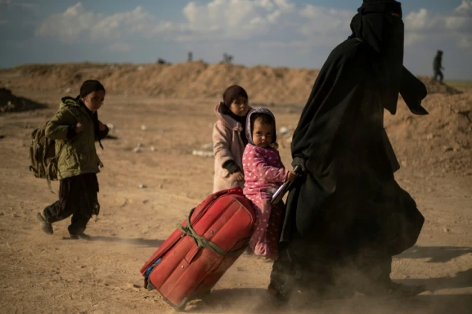 Une femme et ses enfants ayant fui le réduit du groupe Etat islamique (EI) dans l'est de la Syrie le 6 mars 2019
