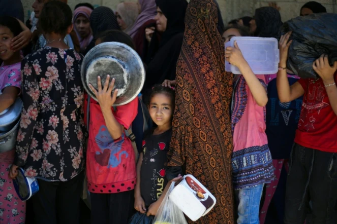 Des enfants attendent dans un centre de distribution d'aide humanitaire à Nousseirat, dans le centre de la bande de Gaza, le 2 juin 2025