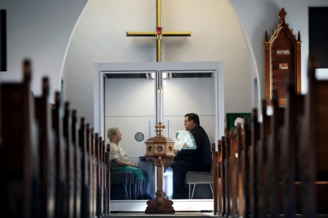 Le pasteur Joel Crouse (D) échange avec une fidèle à l'église luthérienne Saint John d'Ottawa, le 16 septembre 2020