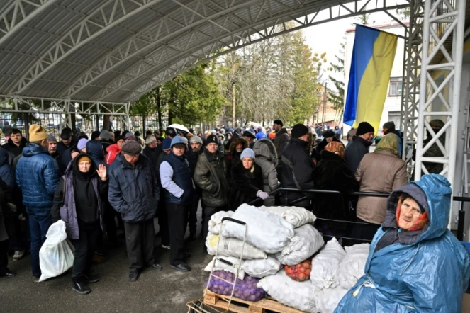 Des habitants font la queue pour s'approvisionner en nourriture et en médicaments, à Boutcha, près de Kiev, le 3 avril 2022