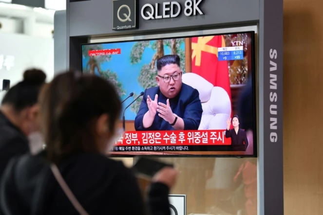 Des passants regardent des images d'archives du dirigeant nord-coréen Kim Jong Un, dans une gare de Séoul, le 21 avril 2020