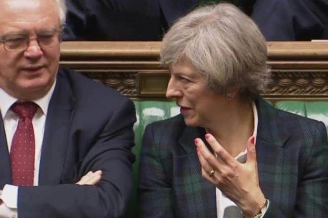 Le ministre chargé du Brexit, David Davis (G), discute avec la Première ministre Theresa May à l'ouverture des discussions devant la Chambre des Communes, le 31 janvier 2017