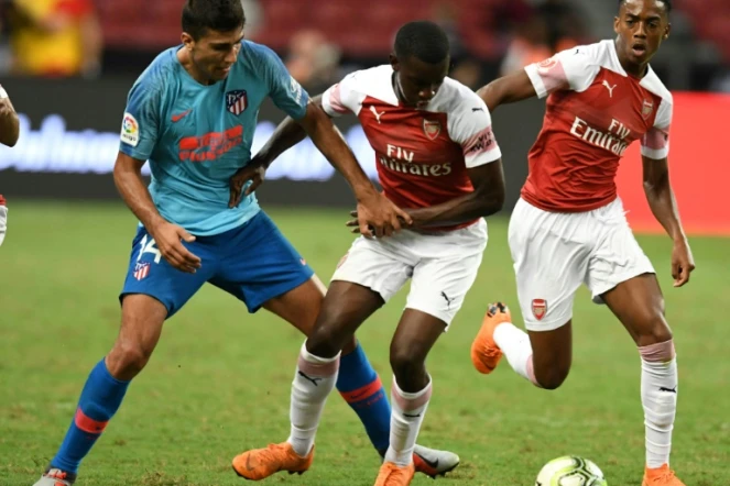 Le joueur de l'Atletico Madrid Rodri (g) à la lutte avec Eddie Nketiah (c), d'Arsenal, lors d'un match amical (international Champions cup) joué le 26 juillet 2018 à Singapour