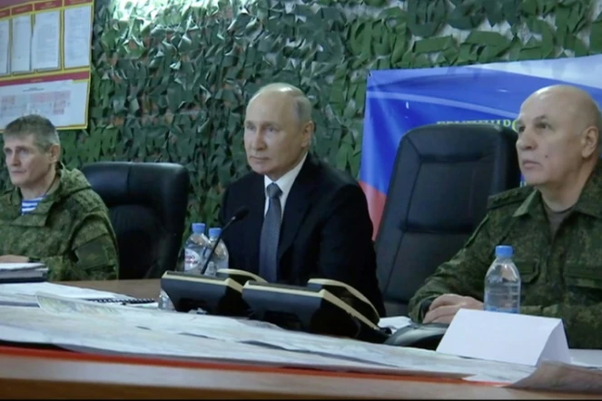 Image tirée d'une vidéo diffusée par la présidence russe le 18 avril 2023 du  président russe Vladimir Poutine (d) visitant le GQ des forces russes dans la région de Kherson, en Ukraine