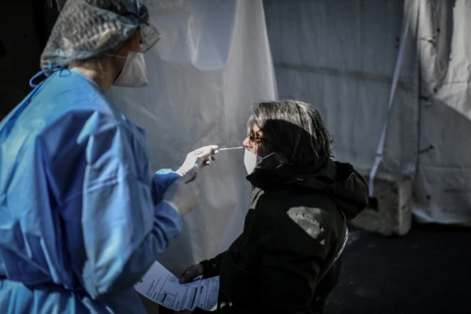 Une soignante procède à un test au Covid-19 sur une femme dans le 17e arrondissement de Paris, le 30 mars 202