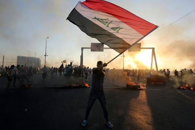 Un manifestant irakien agite le drapeau national le 5 octobre 2019, dans le centre de la capitale Bagdad