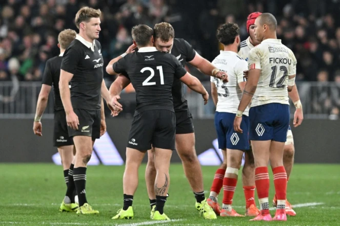 Le Français Gaël Fickou (d.) regarde les joueurs néo-zélandais célébrer leur victoire lors du premier test-match international de rugby entre la Nouvelle-Zélande et la France au stade Forsyth Barr de Dunedin, le 5 juillet 2025