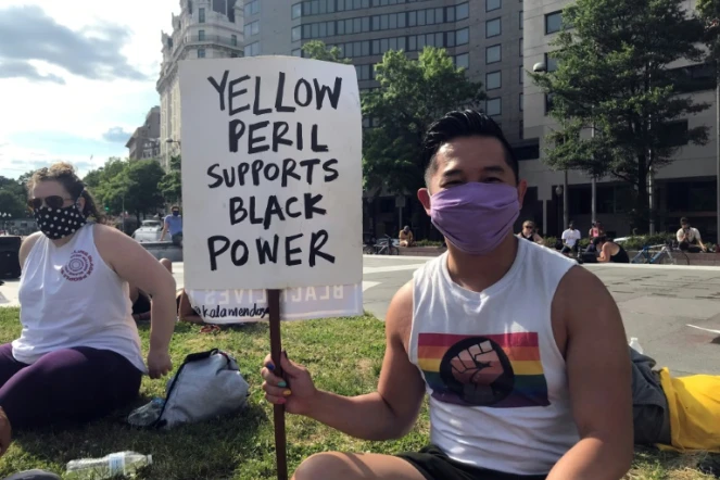 Viet Hoai Tran, 27 ans, tient une pancarte "péril jaune" à une manifestation de soutien au mouvement Black Lives Matter, le 15 juin 2020 à Washington