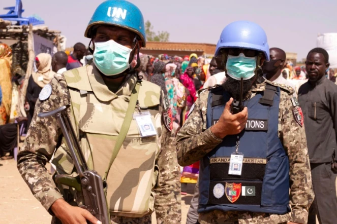 Des membres de la  mission de paix conjointe de l'ONU et de l'Union africaine (Minuad) encadrent une manifestation contre la fin de leur opération dans le pays, dans un camp de déplacés au  Darfour-Sud, le 31 décembre 2020