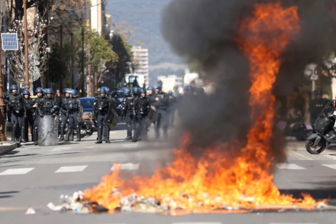 Gendarmes derrière un feu de déchets lors d'une manifestation de lycéens devant la préfecture de Corse du Sud le 10 mars 2022