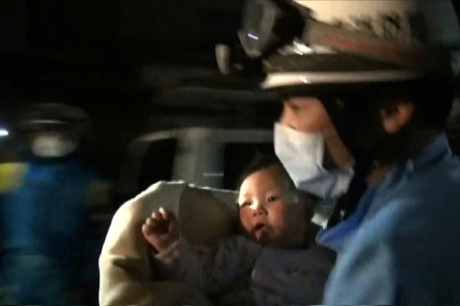 Capture d'écran d'une vidéo fournie par la préfecture de police de Kunamoto le 15 avril 2016 montrant un sauveteur sortant des décombres un bébé de huit mois, après un séisme qui a fait neuf morts au Japon