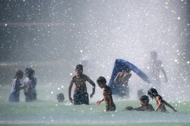 Des enfants se baignent dans le bassin de la Fontaine du Trocadéro, le 2 août 2018 à Paris pendant un épisode de canicule