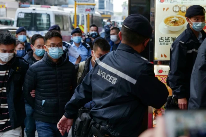 Le rédacteur en chef de Stand News, Patrick Lam, est conduit menotté par la police dans les locaux du site d'information pendant une perquisition, le 29 décembre 2021 à Hong Kong
