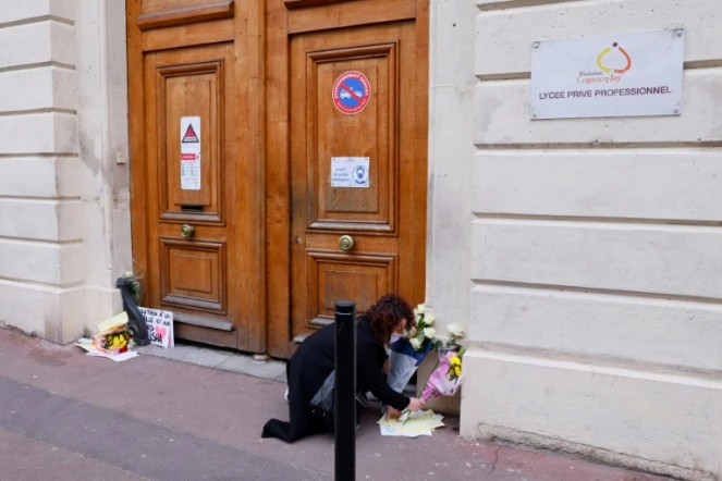 Une femme dépose des fleurs devant le lycée de la jeune Alisha à sa mémoire, le 10 mars 2021