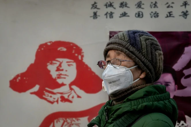 Une femme porte un masque de protection contre l'épidémie de coronavirus, près de la gare de Pékin, le 27 janvier 2020