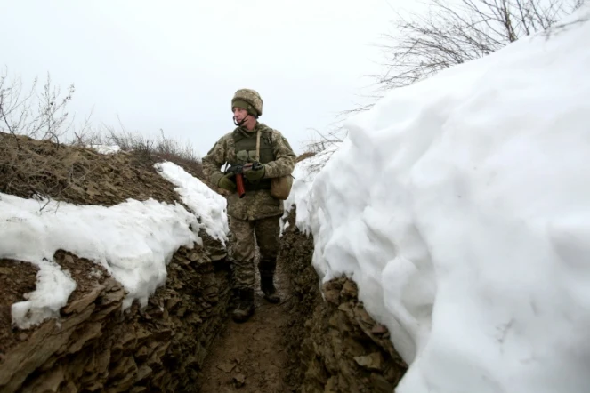 Un militaire ukrainien marche dans une tranchée sur la ligne de front avec les séparatistes prorusses près du village de Luganske, dans la région de Donetsk, le 11 janvier 2022  