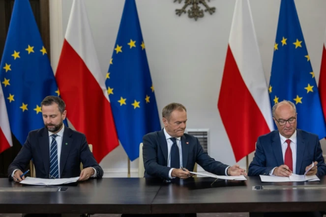 Les dirigeants (de gauche à droite) Wladyslaw Kosiniak Kamysz du parti de la Troisième voie, Donald Tusk de la Coalition civique et Wlodzimierz Czarzasty du parti de gauche signent l'accord de coalition au parlement polonais à Varsovie le 10 novembre 2023