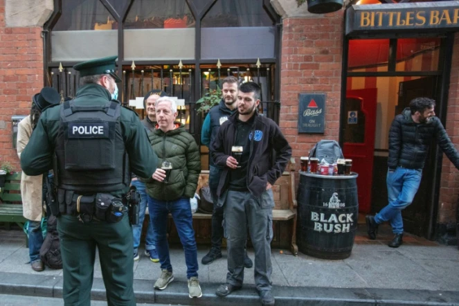 Un policier s'entretient avec les clients d'un bar à Belfast, en Irlande du Nord, le 16 octobre 2020