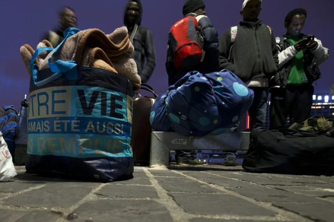 Des migrants ramassent leurs affaires, se préparant à quitter leur camp de fortune près de la gare d'Austerlitz à Paris, le 17 septembre 2015