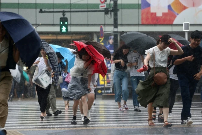 Les passants à Tokyo se protègent de la pluie provoquée par le typhon Jongdari, le 28 juillet 2018