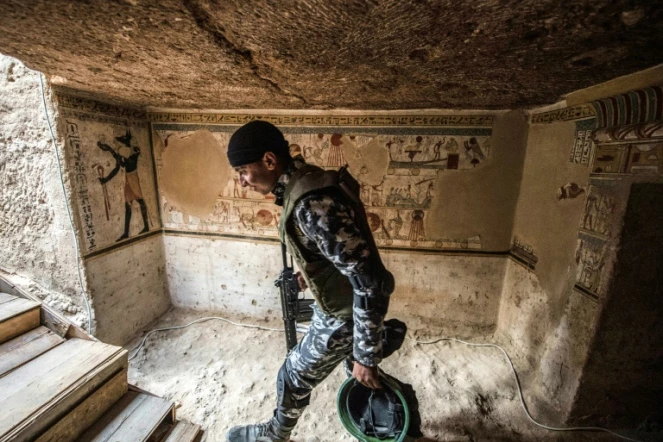 Un membre des forces de sécurité égyptiennes à l'entrée d'une tombe datant de 2.000 ans dévoilée le 5 avril 2019 à Akhmim