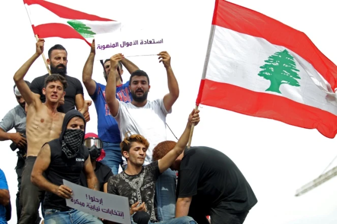 Des manifestants libanais agitent le drapeau national à Beyrouth, le 18 octobre 2019