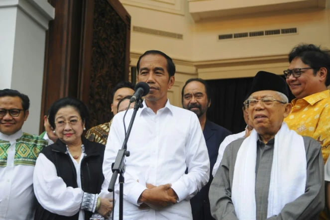 Le président indonésien Joko Widodo (C) et le candidat à la vice-présidence, le prédicateur conservateur Ma'ruf Amin (D) lors d'une conférence de presse à Jakarta le 18 avril 2019
