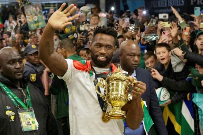 Le capitaine sud-africain Siya Kolisi salue la foule venue accueillir les champions du monde de rugby à l'aéroport de Johannesburg le 31 octobre 2023