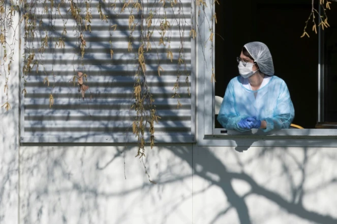 Un membre du personnel soignant se repose quelques minutes à la fenêtre de l'hôpital Emile Muller à Mulhouse, le 24 mars 2020 