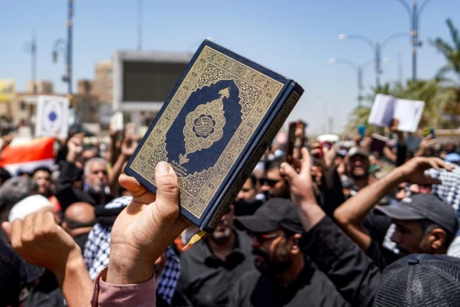 Des manifestants brandissent le Coran durant une manifestation après la prière du vendredi à Kufa, près de Najaf, en Irak