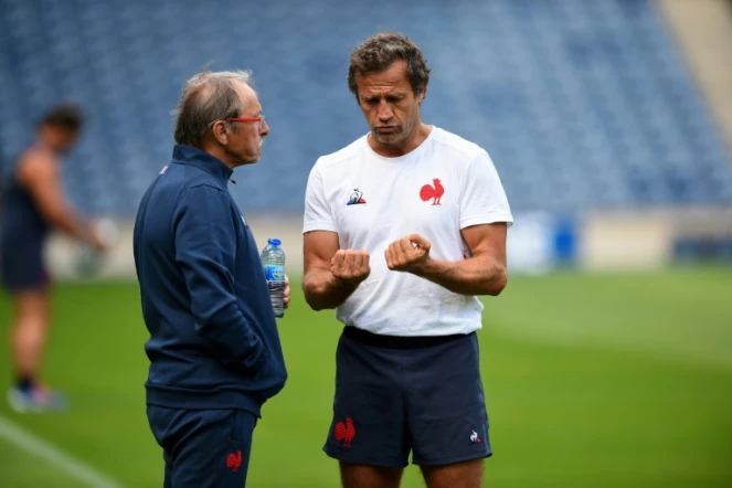 Le sélectionneur du XV de France Jacques Brunel échange avec son adjoint Fabien Galthié lors d'une séance d'entraînement de l'équipe à Édimbourg, le 23 août 2019