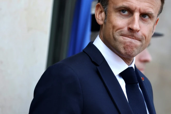 Le président français Emmanuel Macron se tient devant le palais présidentiel de l'Elysée à Paris, le 16 juin 2023