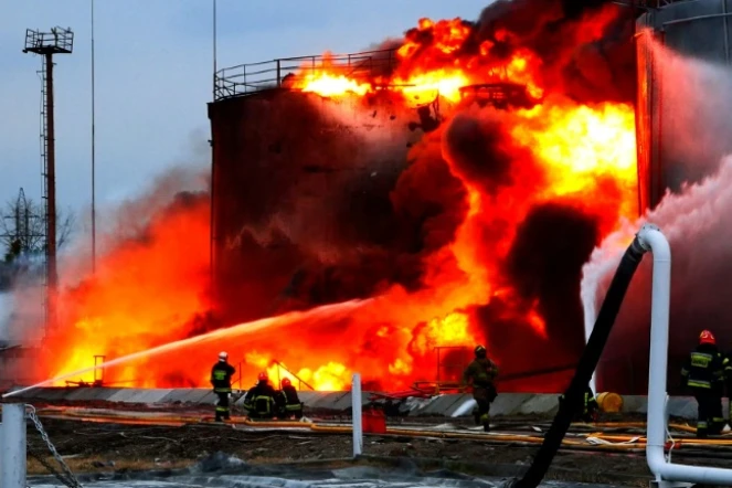 Photo prise et fournie par les services d'urgence ukrainiens montrant les pompiers à l'oeuvre pour éteindre un incendie causé par des frappes de missile russes sur une citerne de carburant à Lviv, en Ukraine, le 26 mars 2022