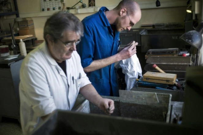 Un jeune homme, alors employé avec un contrat de génération, travaille aux côtés d'un employé plus âgé, le 25 mars 2013 dans un atelier d'assemblage d'optique à Mitry-Mory, en Seine-et-Marne