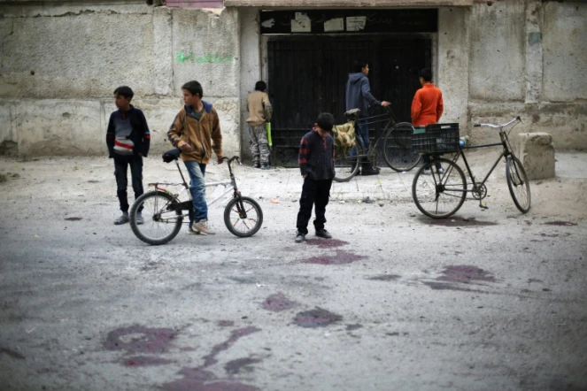 Des enfants sur le site d'un bombardement du régime qui a tué au moins quatre écoliers selon l'OSDH, le 31 octobre 2017 à Jisrine en Syrie