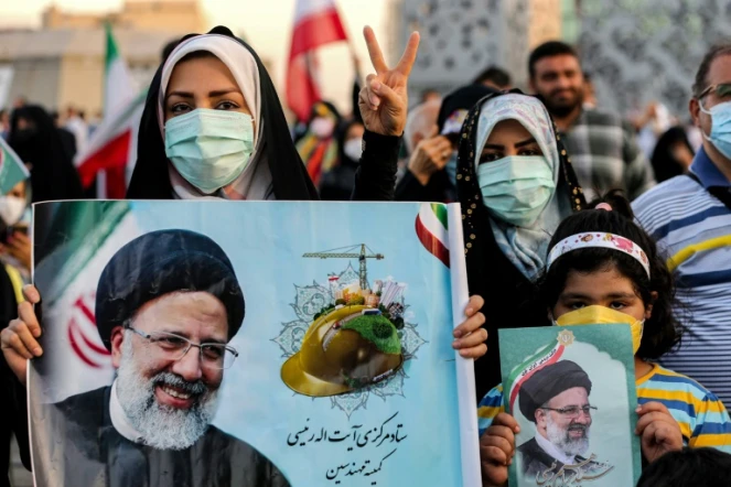Des Iraniennes tiennent le portrait du nouveau président iranien élu Ebrahim Raïssa, le 19 juin 2021 à Téhéran
