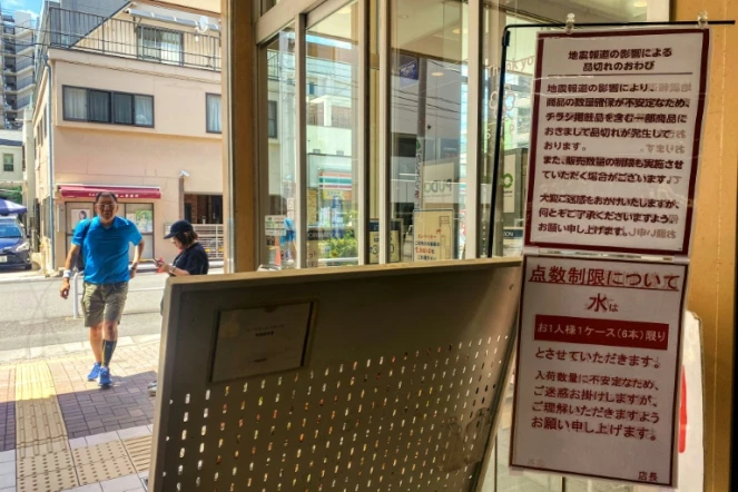 L'entrée d'un supermarché où des affiches indiquent des ruptures de stock pour certains produits et des restrictions de vente pour l'eau, le 10 août 2024 dans le district de Sumida, à Tokyo