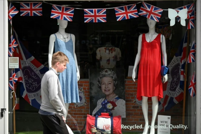 Passant devant une vitrine décorée à l'occasion du jubilé de platine d'Elizabeth II, à Colchester dans l'est de l'Angleterre, le 31 mai 2022