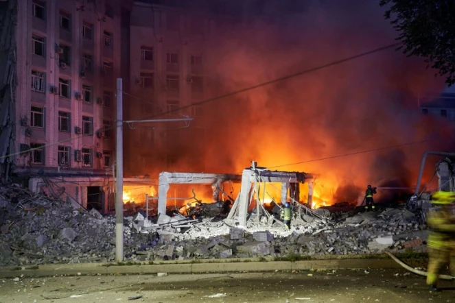 Des pompiers luttent contre un incendie dans un bâtiment après une frappe russe, le 28 juillet 2023 à Dnipro, en Ukraine