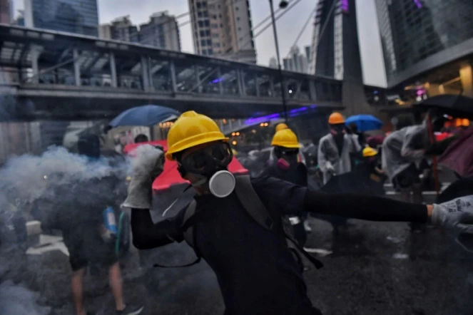 Des manifestants retournent des gaz lacrymogènes contre la police dans la banlieue de Tsuen Wan à Hong Kong le 25 août 2019