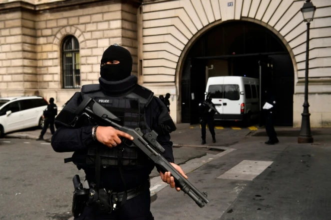 Un policier armé monte la garde devant le palais de Justice de Paris, alors qu'arrive le van transportant Jawad Bendaoud, le 24 janvier 2018