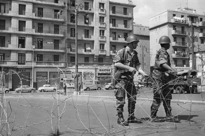 Des soldats ont procédé au bouclage du quartier européen d'Alger du "Champ de manoeuvres" et montent la garde devant les barbelés posés pour isoler le quartier le 04 mai 1962, après la signature des accords d'Evian