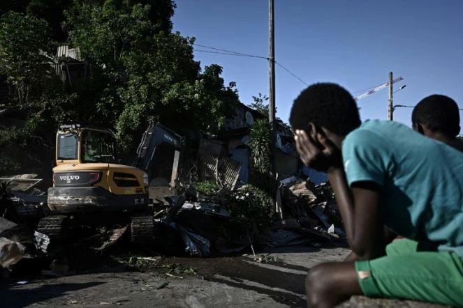 Des habitants assistent à la démolition des cases en tôle du bidonville Talus 2, le 22 mai 2023 à Mayotte