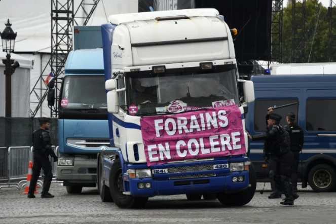 Des policiers devant un cortège de camions de forains, le 12 septembre 2017 à Paris