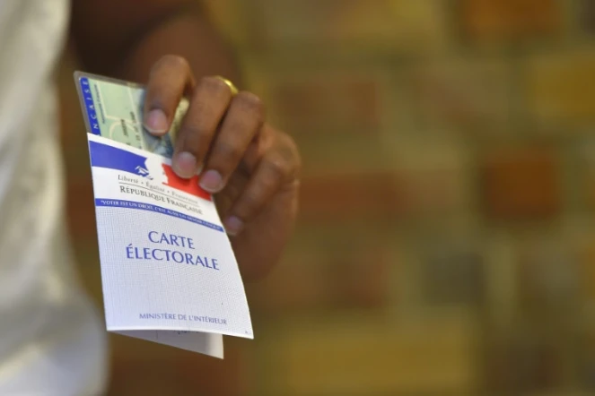 Une femme tient en main sa carte d'électeur et sa pièce d'identité lors des élections législatives à Nantes, le 18 juin 2017