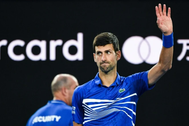 Le Serbe Novak Djokovic bras levé après sa victoire face au Japonais Kei Nishikori en quarts de finale de l'Open d'Australie, le 23 janvier 2019 à Melbourne