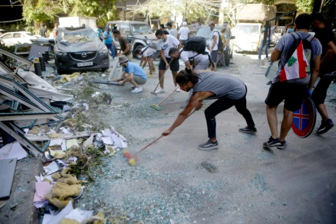 Des bénévoles libanais nettoient les rues de la capitale libanaise Beyrouth après les explosions au port, le 5 août 2020