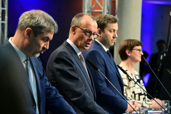 Le conservateur (CDU) allemand Friedrich Merz (au centre) dévoile son accord de gouvernement avec les sociaux-démocrates, le 9 avril 2025 à Berlin
